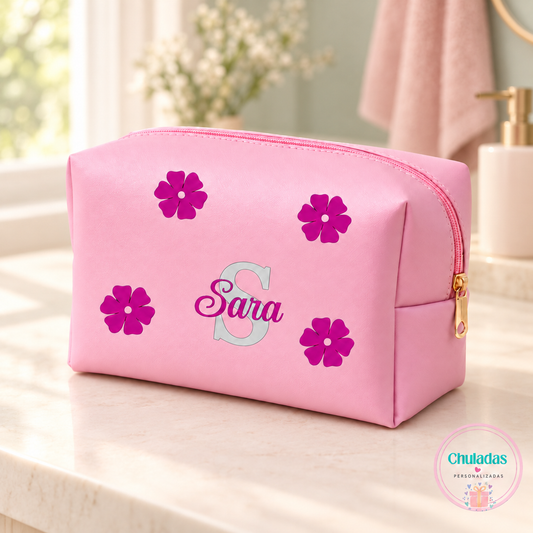 Neceser rosa personalizado con inicial S, nombre Sara y flores, en un ambiente de baño pastel. Imagen de presentación generada.